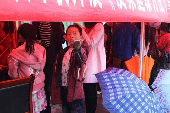 因?yàn)橛晗碌奶?，小男孩玩起了接水游戲? complete=