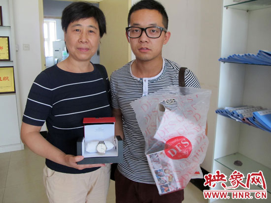 失主王女士從B11車(chē)長(zhǎng)吳杰手中拿回自己幫朋友捎的免稅名表 失主王女士從B11車(chē)長(zhǎng)吳杰手中拿回自己幫朋友捎的免稅名表