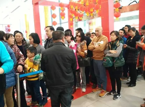 排隊(duì)領(lǐng)年貨，一家老小齊上陣。