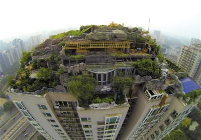 　　昨日，身穿橘黃色馬甲的工作人員在人濟山莊樓頂拆除違章建筑。新京報記者 吳江 攝