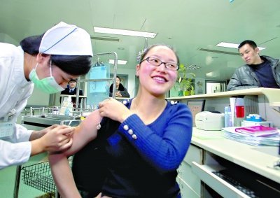 昨日，向雪敏在同濟醫(yī)院血液科病房打動員劑，丈夫陳武右在身后注視著妻子 記者傅克強