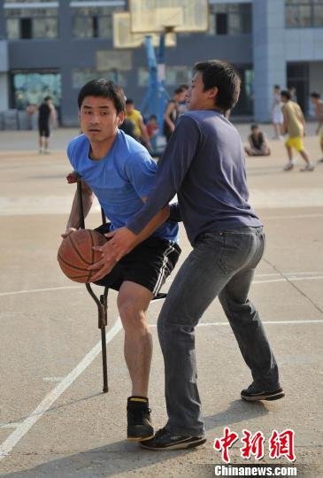 圖為拄著拐杖的瞿詩濤和同學(xué)搶球。劉占昆攝