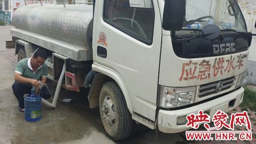 柘城縣黃山小區(qū)的居民，因為停水，只能接了自來水再往樓上搬。