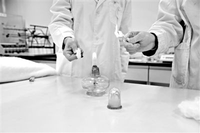 實驗人員操作的燃燒檢測法中，真蠶絲離開火焰就熄滅(左)。