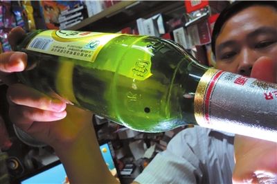 這瓶未開封的燕京啤酒內(nèi)有一顆黑色懸浮物。京華時(shí)報(bào)記者 徐曉帆 攝