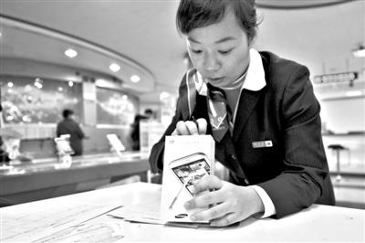 11月6日，北京移動西直門營業(yè)廳的工作人員在為顧客購買的4G手機(jī)登記。新華社發(fā)