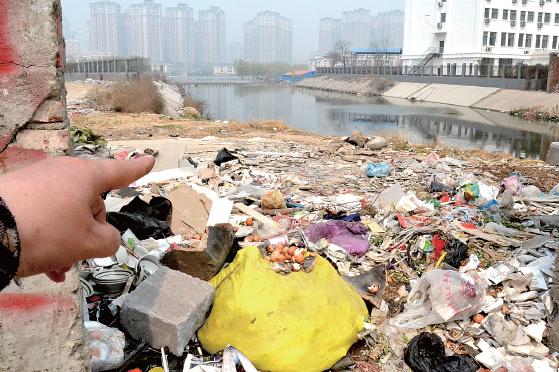 金水河長江路橋下河水發(fā)臭，水邊堆放眾多垃圾