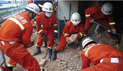 消防人員在清理熔鹽爐倒塌的廢墟。