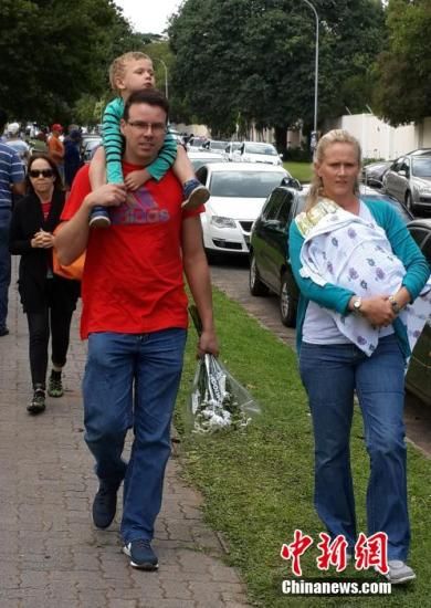 圖為一個(gè)白人家庭，由父母帶著孩子到曼德拉家門(mén)外悼念。中新社發(fā) 宋方燦 攝