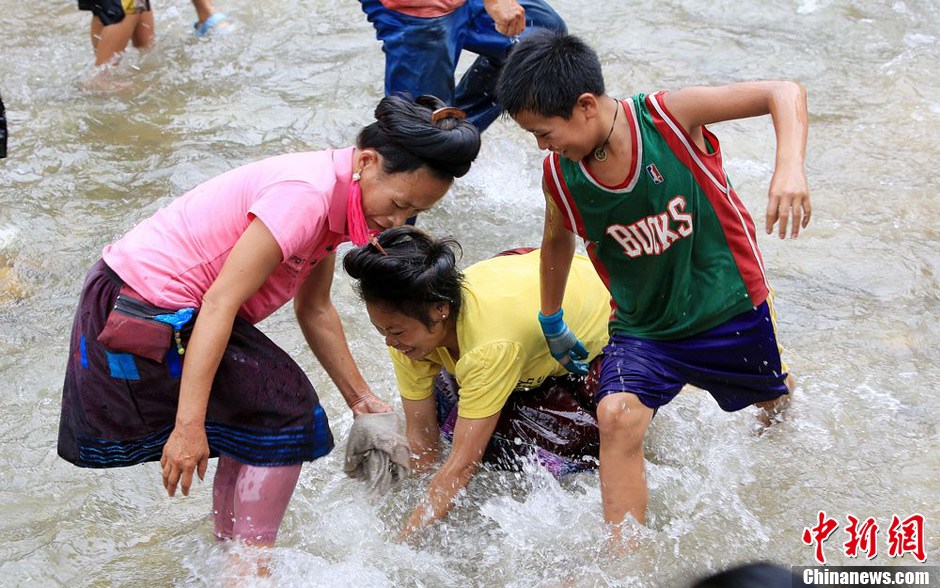 7月9日，村民在小河里摸魚搶魚。譚凱興 攝