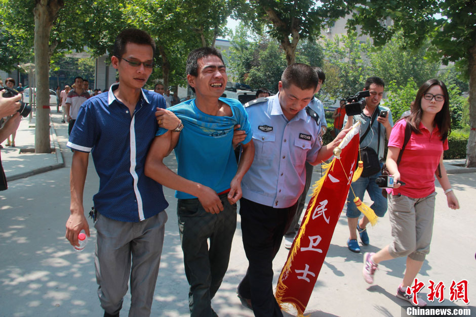 圖為獲救嬰兒父親情緒一度失控，當(dāng)?shù)鼐焦ぷ魅藛T對其進(jìn)行攙扶。張一辰 攝