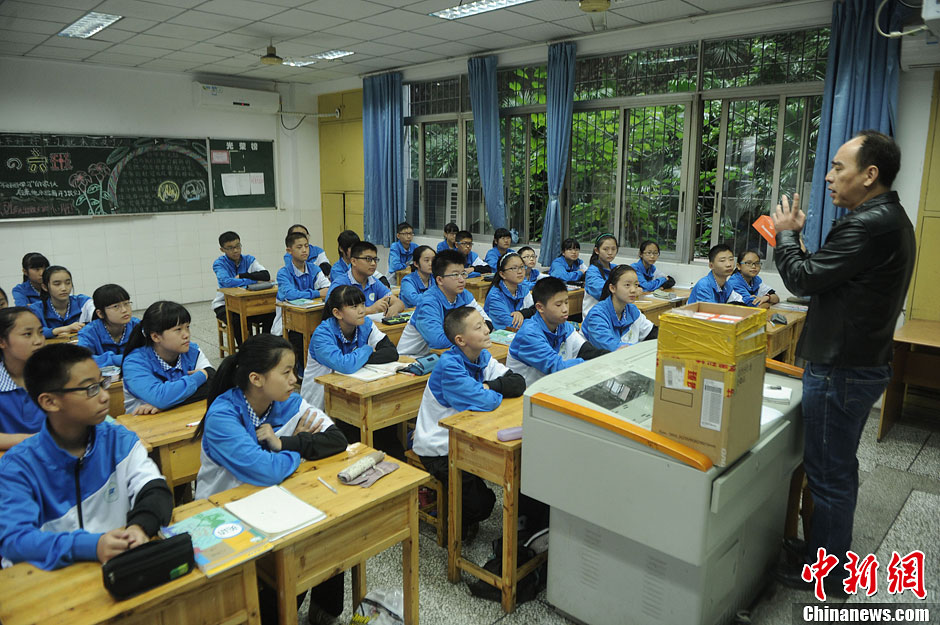 圖為老師正在向同學們講解用非智能手機對他們的好處。