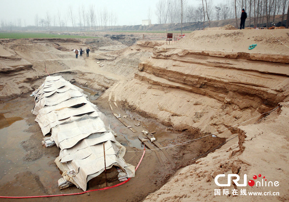 2014年1月6日，河南洛陽(yáng)古沉船發(fā)掘現(xiàn)場(chǎng)，近日有雨雪天，考古人員給古沉船披上一層“雨衣”。