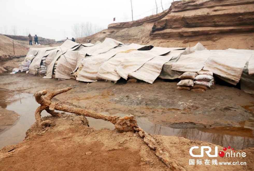 2014年1月6日，河南洛陽(yáng)古沉船發(fā)掘現(xiàn)場(chǎng)，古沉船鐵錨從見(jiàn)天日，靜靜地躺在古船旁。