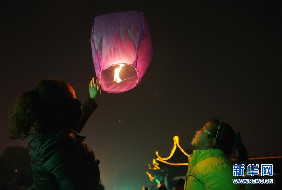　1月30日，游客在江蘇省鎮(zhèn)江市金山公園門口放飛孔明燈。