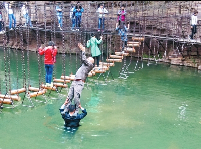 中年男游客正踩著景區(qū)安全員郭小明的肩膀過(guò)河。網(wǎng)友“@我的小名叫張孩”供圖