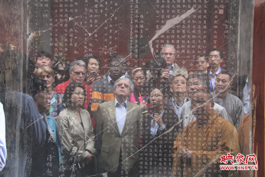 在一塊石碑前，少林寺方丈正在講解