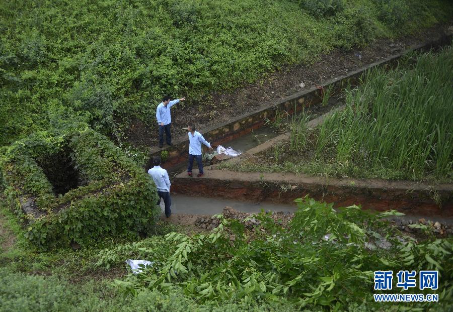 5月18日，工作人員在槽罐車泄漏現(xiàn)場(chǎng)附近的水渠邊查看情況。