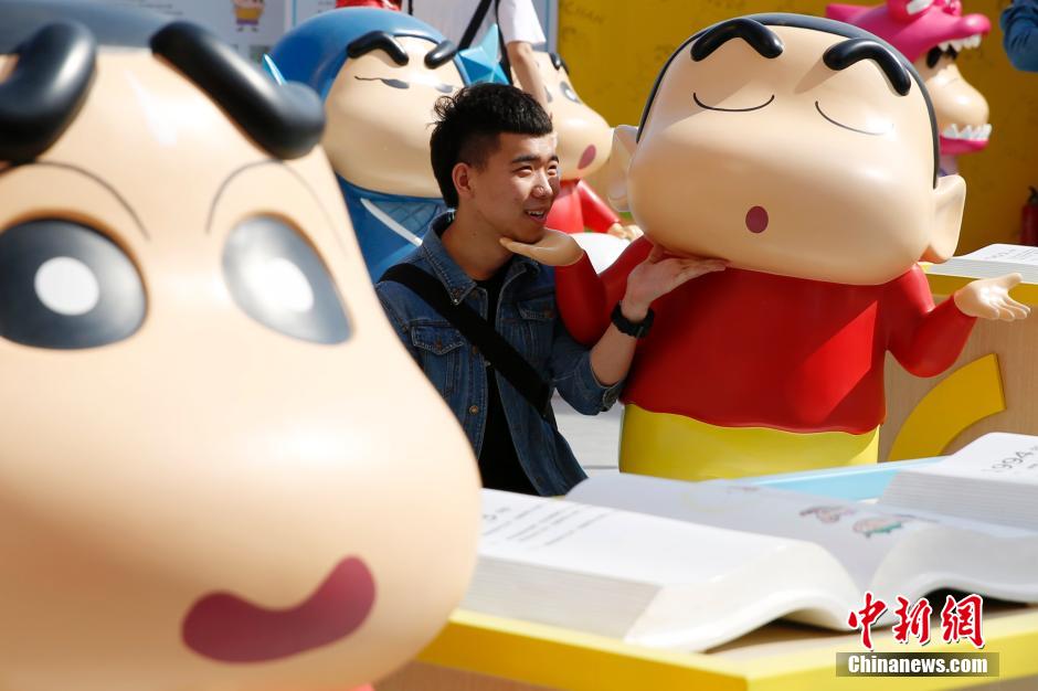 4月22日，游客與蠟筆小新合影?！跋灩P小新25周年紀(jì)念特展”日前在北京開展，吸引了不少市民游客。