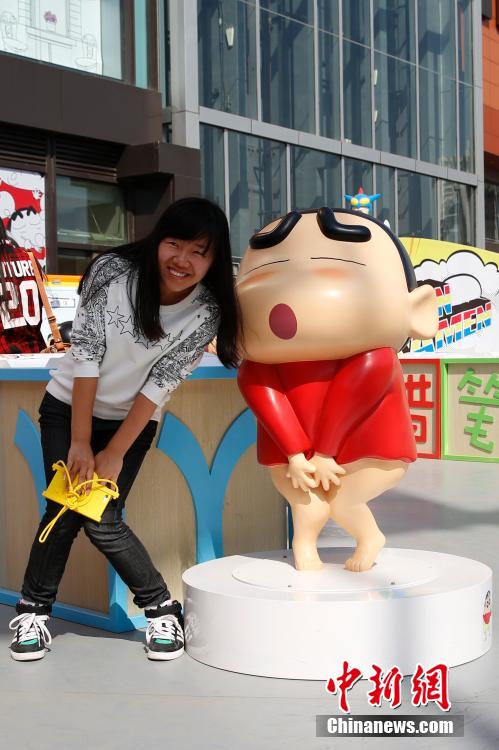 4月22日，游客與蠟筆小新合影?！跋灩P小新25周年紀(jì)念特展”日前在北京開展，吸引了不少市民游客。