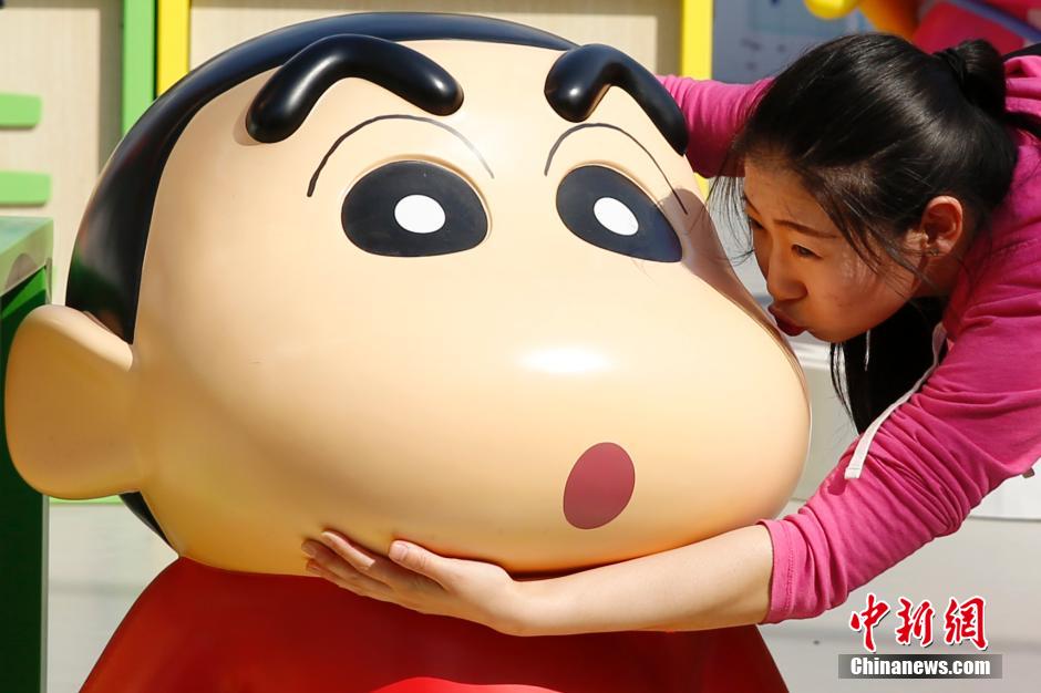 4月22日，游客與蠟筆小新合影。“蠟筆小新25周年紀(jì)念特展”日前在北京開展，吸引了不少市民游客。