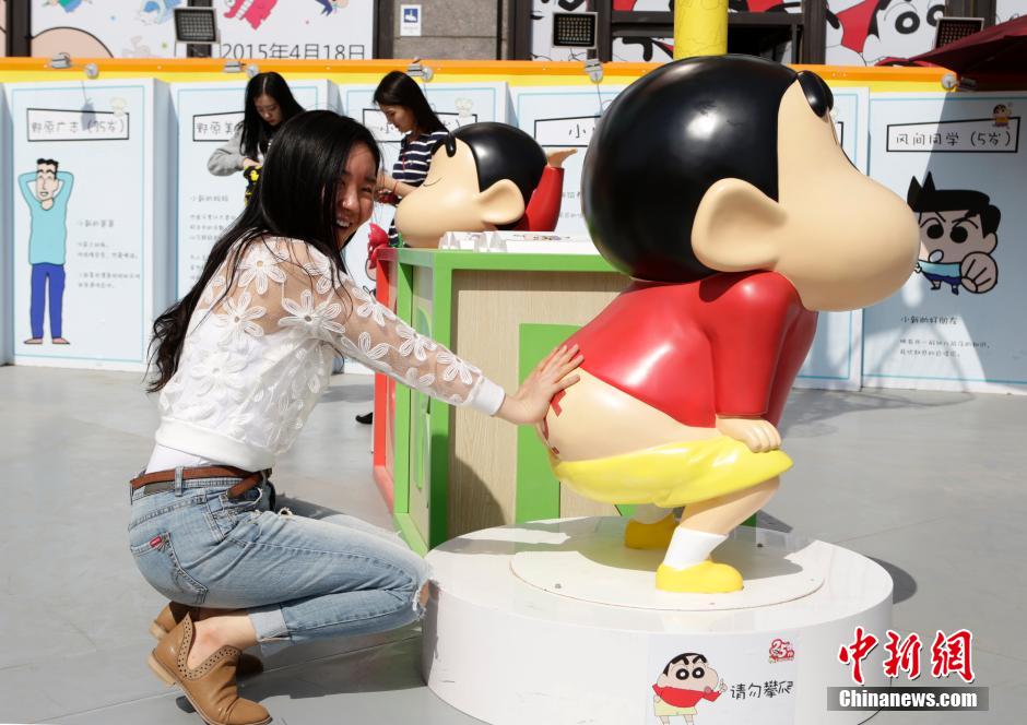 4月22日，游客與蠟筆小新合影。“蠟筆小新25周年紀(jì)念特展”日前在北京開展，吸引了不少市民游客。