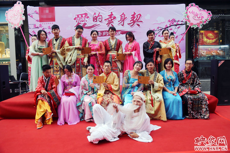 現(xiàn)場(chǎng)8對(duì)兒年輕男女舉起“賣身契”集體拍照。