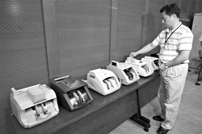 昨日，央行工作人員用各種驗(yàn)鈔機(jī)對(duì)C1F9假幣進(jìn)行測(cè)試，機(jī)器均能及時(shí)作出異常報(bào)警反應(yīng)。新京報(bào)記者 浦