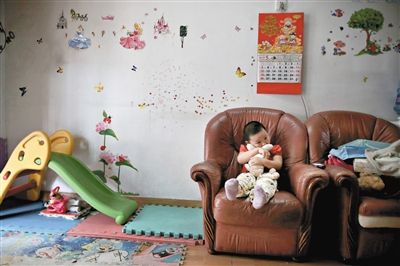 6月14日，未婚媽媽于軍的家里。女兒悅悅抱著兔子玩偶，在聽媽媽手機(jī)上的兒歌，這個(gè)4歲女孩喜歡兔子。