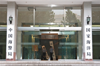 昨日，中國海警局掛牌成立。原國家海洋局和中國海監(jiān)總隊的牌匾被摘下，國家海洋局和中國海警局的新牌匾換上。黃冉 攝