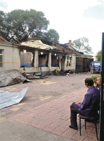 7月27日，海倫聯(lián)合敬老院內(nèi)，幾名老人看著對(duì)面被燒毀的特護(hù)病房。新京報(bào)記者 涂重航 攝