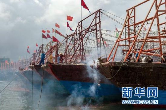 2013年8月1日 南海開漁日 臨高迎新港 8月1日，海南省臨高縣漁民在船上鳴放鞭炮慶祝武蓮港開港。