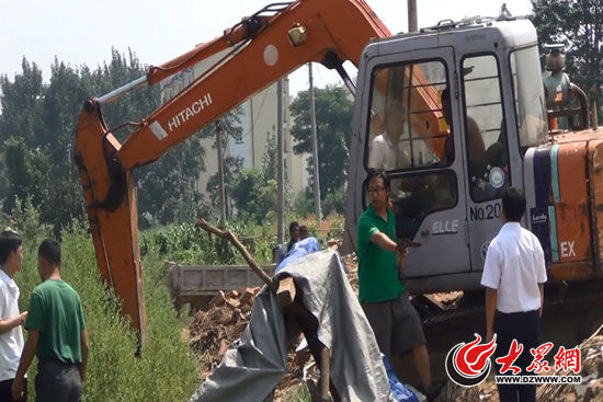 陳寶成手持自制刀斧守在挖掘機旁阻止便衣民警靠前。（視頻截圖）