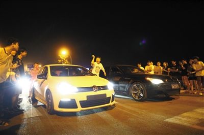 8月24日晚，東壩中街飆車現(xiàn)場，兩輛車并排等待出發(fā)指令，旁邊許多愛好者前來觀看比賽。新京報(bào)記者