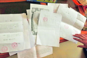 60歲的市民仇先生為了辦理公證所需的這些證明材料,半個(gè)月時(shí)間里跑了30多趟腿。記者　李萌博　攝