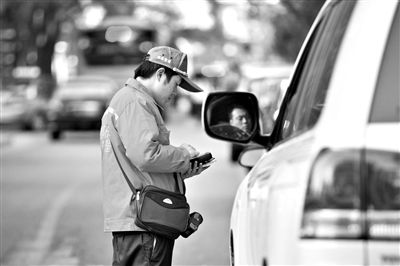 10月15日，朝陽區(qū)東大橋路，停車管理員從腰間掏出一個專用POS機，正在錄入停車信息。新京報記者 周崗峰 攝