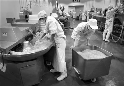 昨日，位于順義李遂開發(fā)區(qū)的慶豐包子鋪配送中心生產車間，工人們正在斬拌胡蘿卜餡料。