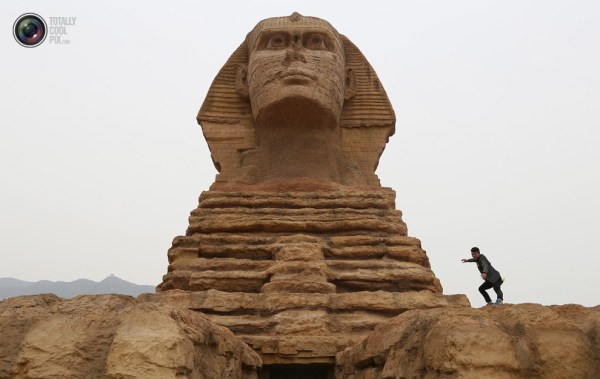 石家莊郊外，一名男子與山寨版獅身人面像合影留念。