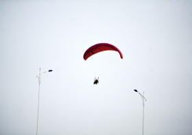 10月25日下午，動力傘從一對路燈上空飛過