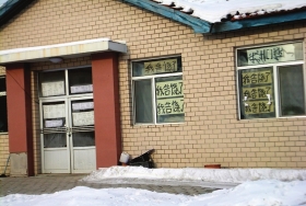 伊春市帶嶺區(qū)一排破舊的平房，房間窗戶上貼滿了“我告饒了”的字樣。