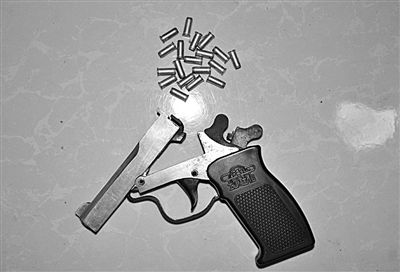 警方從搶劫嫌疑人處起獲的贓款和發(fā)令槍、子彈。警方供圖