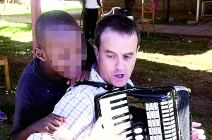 西蒙·伍德在教孩子唱歌，歡樂的歌聲掩蓋不住邪惡的目的。