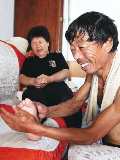 慈成富為老伴按摩。