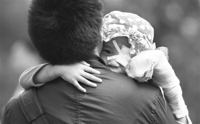 昨日，北京同仁醫(yī)院，被砍傷的彤彤趴在舅舅的肩上。他們剛剛掛完號，正準(zhǔn)備回旅館。新京報(bào)記者 尹亞飛 攝