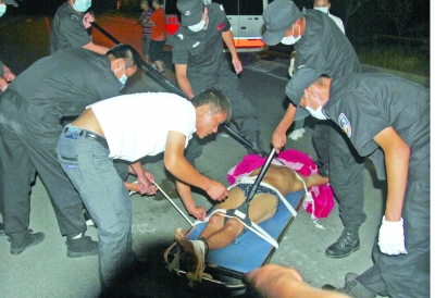 眾人合力將狂犬病發(fā)作的江某控制住。 孫東城 攝