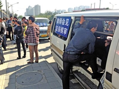 昨日，朝陽區(qū)看守所門前有人排隊。大門外還停有多輛寫有“律師會見”字樣的車。