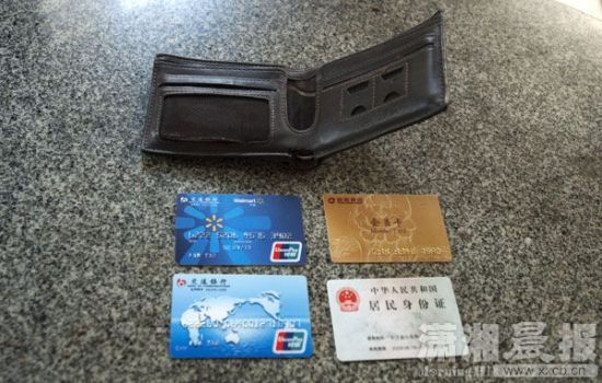 12月24日，長沙雨花區(qū)美聯(lián)天驕城，當(dāng)事人范先生展示小偷寄回的錢包、身份證和銀行卡。