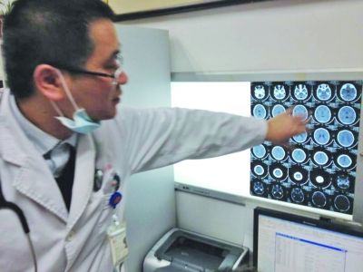 醫(yī)生在查看男孩的腦部CT片。薛馬義 攝