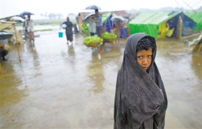 5月14日，緬甸若開邦實兌難民營，羅興亞族難民在雨中行走。熱帶風(fēng)暴“馬哈森”即將登陸緬甸，這里的難民開始乘船撤離。