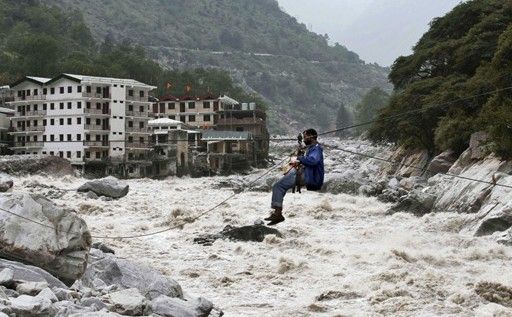 一名印度男子靠繩索渡河。